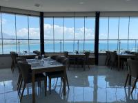 un ristorante con tavoli e sedie e grandi finestre di Finike Marina Hotel a Finike