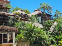 un edificio con una palmera delante en Eco Hostal La Perla Tayrona, en El Zaino