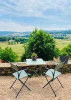 a table and two chairs sitting on top of a stone wall at Mazille Les Trois Monts in Mazille