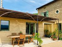 a patio with a wooden table and chairs at Mazille Les Trois Monts in Mazille