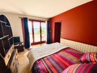 a bedroom with red walls and a bed and a window at Mazille Les Trois Monts in Mazille