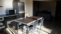 a kitchen with a table with chairs and a refrigerator at Au milieu des vignes piscine chauffée clim dans maison vigneronne in Mondragon