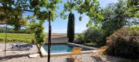 a backyard with a swimming pool and two chairs at Au milieu des vignes piscine chauffée clim dans maison vigneronne in Mondragon