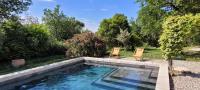 a swimming pool with two chairs next to it at Au milieu des vignes piscine chauffée clim dans maison vigneronne in Mondragon