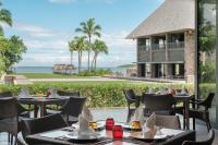 um restaurante com mesas e cadeiras e o oceano em InterContinental Fiji Golf Resort & Spa by IHG em Natadola