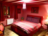 a red bedroom with a bed with red walls at Maison en Ardèche avec bain suédois et Sauna in Saint-Symphorien-de-Mahun