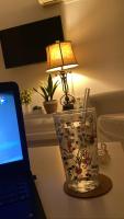 a desk with a laptop and a glass vase with a lamp at Serenity Apart in Antalya