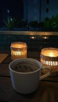 a cup of coffee sitting on a table with candles at Serenity Apart in Antalya