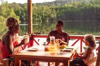 Kolombangara IslandLeleana Resort Kolombangara的坐在桌子上与孩子在一起的男人和女人