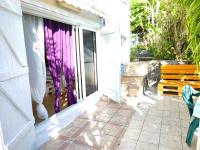 a porch with a bench and a window with purple curtains at Studio avec vue sur la mer jardin clos et wifi a Vieux habitants a 1 km de la plage in Vieux-Habitants
