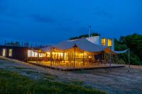 a tent with tables and chairs in front of a building at Ursa Mica Glamping Resort in Şirnea