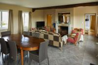 a living room with a couch and a table and chairs at La Maison de Charlotte in Doudeville