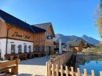 um edifício com uma cerca ao lado de uma massa de água em Narzissendorf Zloam - Ferien & Abenteuer am Grundlsee em Grundlsee