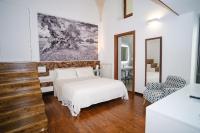 a white bedroom with a bed and a mirror at Welcome Ostuni b&amp;b in Ostuni