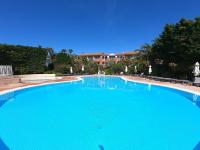 a large swimming pool with blue water at Presqu&#39;ile de Giens - Hameau de la Pinede in Hyères