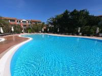 a large blue swimming pool in a hotel at Presqu&#39;ile de Giens - Hameau de la Pinede in Hyères