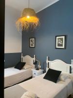 a bedroom with two beds and a chandelier at Molino El Mastral in Tarifa