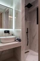 a white bathroom with a sink and a mirror at NERO SEASCAPE SUITES in Fanari