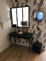 a mirror and a desk in a room with a wall at Appartement T2 Manoir de Malville in Nantes