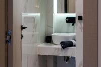 a white bathroom with a sink and a mirror at NERO SEASCAPE SUITES in Fanari
