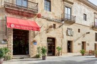 una fachada de un edificio con un toldo rojo en NH Collection Cáceres Palacio de Oquendo, en Cáceres