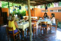 a group of people sitting at tables in a restaurant at Posada Pittier in Choroní