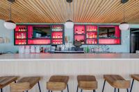 BeachWalk at Sea Bright في Sea Bright: بار به كراسي خشبية وخزائن حمراء