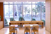 Un restaurante con mesas y sillas y un gran ventanal. en Dormy Inn PREMIUM Kushiro, en Kushiro