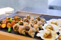 Una bandeja de comida con ostras y otros alimentos. en Dormy Inn PREMIUM Kushiro, en Kushiro