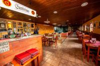 um restaurante com mesas, cadeiras e um bar em Penzion Myslivna em Lednice