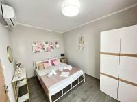 a small bedroom with a bed with pink pillows at ENDLESS BLUE Dream Villa in Paleo Tsifliki