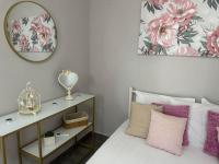 a bedroom with a bed with pink pillows and a mirror at ENDLESS BLUE Dream Villa in Paleo Tsifliki