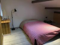 a bedroom with a bed with a red and white blanket at Gîte Le Buron in Chazelles