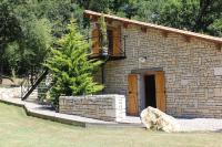 a small stone building with a tree in front of it at Gîte Le Buron in Chazelles