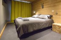 a bedroom with a large bed with a green curtain at HaKaJu Appartement 10 personnes à Val Cenis in Lanslebourg-Mont-Cenis