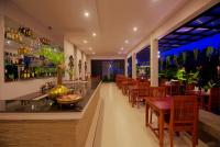 un ristorante con bar con tavoli e sedie in legno di New Riverside Hotel a Siem Reap