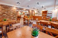 a restaurant with wooden tables and chairs and a brick wall at Panorama Górska Wisła Resort & SPA in Wisła