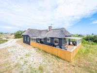 a house on the beach with a thatched roof at Holiday home Hvide Sande LXIX in Havrvig