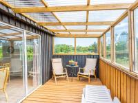 a screened in porch with chairs and a table at Holiday home Hvide Sande LXIX in Havrvig