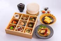 uma mesa com uma caixa de comida e um prato de comida em OliveBay Hotel em Saikai