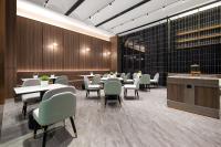 a restaurant with tables and chairs in a room at Morninginn,Puji in Liuyang