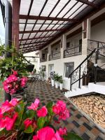 Un patio con flores rosas y toldo en un edificio. en Casa RIO, en Sighişoara