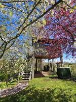 a tree with pink flowers on a house with a ladder at Au Refuge Des 3 Ours - Chambres d&#39;hôtes et cabanes in Essuiles-Saint-Rimault