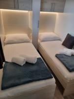 two beds in a room with white sheets and towels at CHARTA Mobile Home Meon in Drage