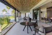 un patio interior con mesas y sillas y vistas al océano en The Jing, en Tejakula