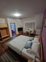 a bedroom with a large bed and a living room at Guest house Wolf II in Plitvička Jezera