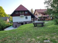 a building with a picnic table in the grass at Guest house Wolf II in Plitvička Jezera