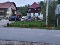 a house with a car parked on the side of a road at Guest house Wolf II in Plitvička Jezera