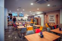 un restaurante con mesas y sillas y un hombre parado en la cocina en Hotel Centrum Malbork, en Malbork