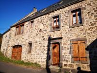 an old stone building with wooden doors and windows at Maison de Varennes in Chambon-sur-Lac